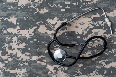 Stethoscope lies on the uniform of a US soldier. The concept of health care, military insurance, state care. Top view. Mixed mediaの写真素材