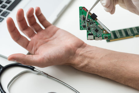 High angle of anonymous medical practitioner in gloves using modern tool to implant blue RFID...