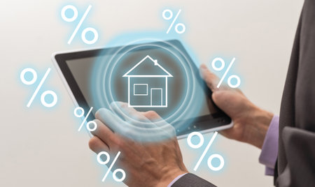 Smart home technology concept. Glowing digital security home lock symbol hologram appearing on smartphone in businesspersons hands. Smarthome safety system automation control app.の写真素材