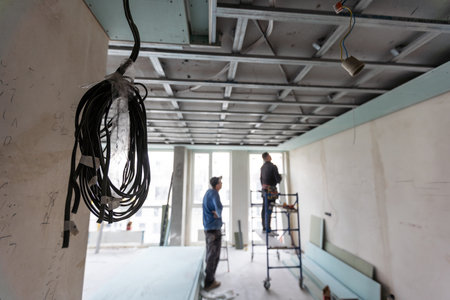 Workers assemble a suspended ceiling with drywallの写真素材