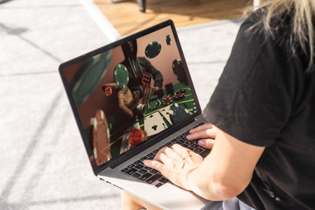 Man betting on sports using laptop at table, closeup. Bookmaker website on screenの写真素材
