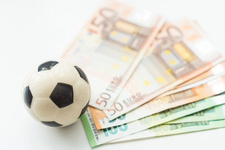 beautiful leather soccer ball lies on a pile of paper euro billsの写真素材