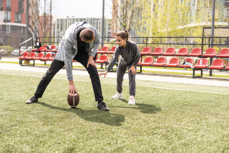 Family Playing American Football Together In Park.の写真素材