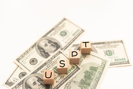 Money, US Dollar. Alphabet in wooden cubes forming the acronym USD over many US dollar banknotes....