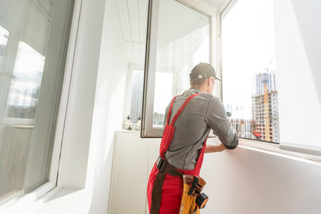 The foreman installs a window frame in the roomの写真素材