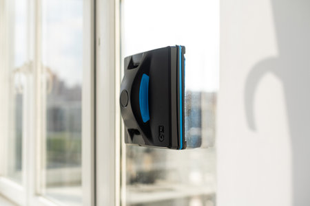 Modern window washer robot performs work on a dirty window. Cleaning the house with smart devices. Automatic window cleaning robot, housekeeperの写真素材