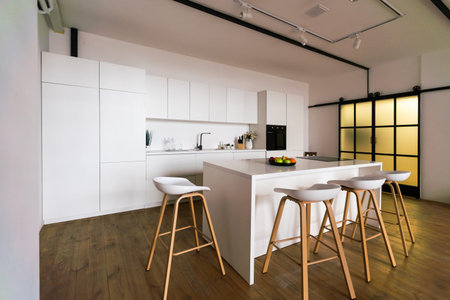 Kitchen in new luxury home with quartz waterfall island, hardwood floors, dark wood cabinets, and...