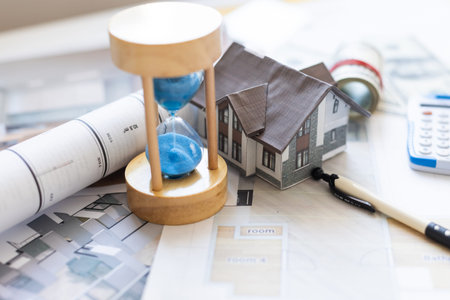 Wooden house and clock. Businessman counting money. Payment of deposit or advance payment for...