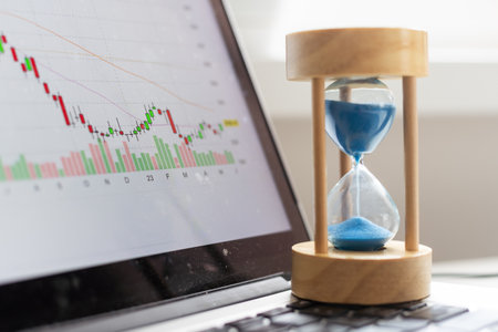 Best time for investment. Hourglass, financial charts and calculator.の写真素材