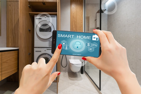 Smart home technology interface on smartphone app screen with augmented reality (AR) view of internet of things (IOT) connected objects in the apartment interior, person holding device.の写真素材