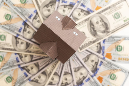 House model is placed on a surface covered with dollar bills symbolize Invest in real estate conceptの写真素材