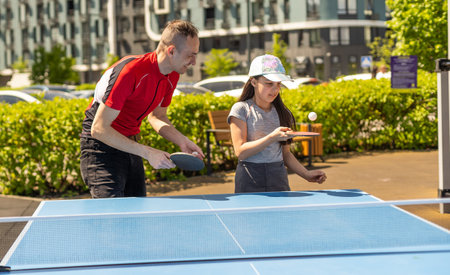 Family playing table tennis outside houseの写真素材