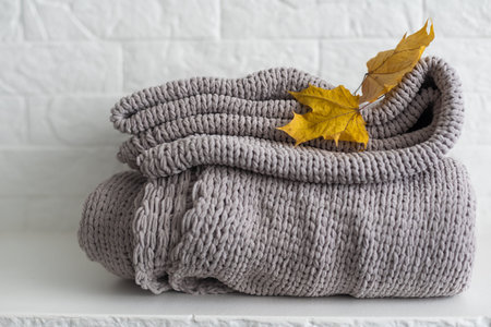 Autumn composition plaid and yellow leaves on a white background.の写真素材