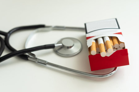 Cigarettes in a first aid tin with stethoscope on a white backgroundの写真素材