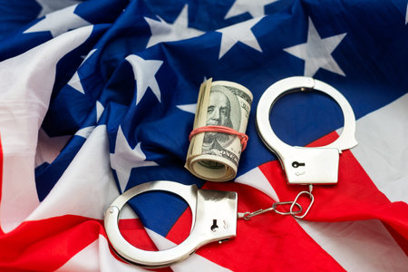 Handcuffs with money on american flag.の写真素材