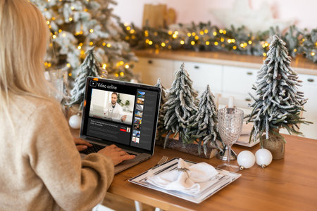 Excited smiling woman have laptop video chat. Young female at home in happy Christmas mood.の写真素材