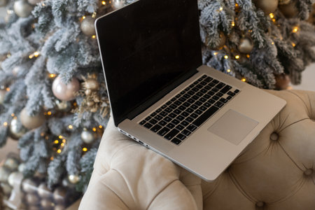 laptop against blurred christmas lights backgroundの写真素材