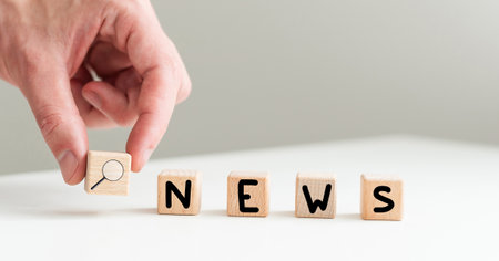 Wooden news sign on a table in an officeの写真素材