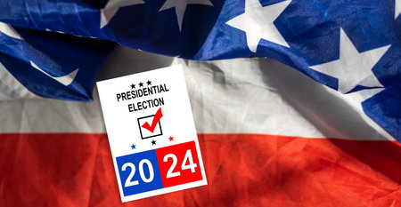 Presidential Election 2024 text on white paper over waving American Flag. Politics and voting conceptual. Top viewの写真素材