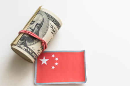 The national flag of China sticking in a pile of american dollars.(series)