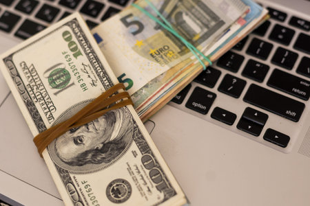 Pile of euro money with Laptop on the table