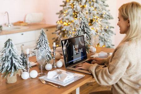 Happy pretty young woman freelancer smiling, working remote at laptop at home before Christmasの写真素材