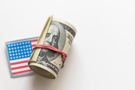 A roll of US dollars with the American flagの写真素材