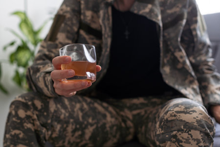 Cropped shot of a hands of young soldier sitting on a sofaの写真素材
