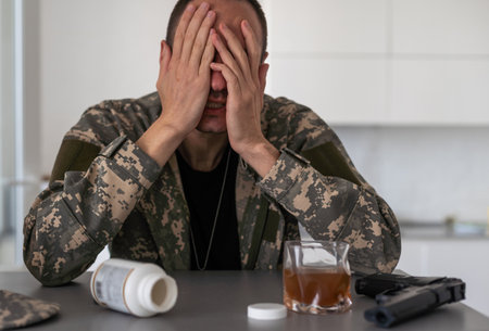 The young man wears a camouflage uniform and shows different gestures. On a gray background in the studio.の写真素材