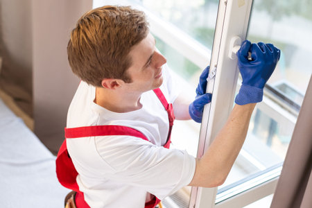 Construction worker installing window in house