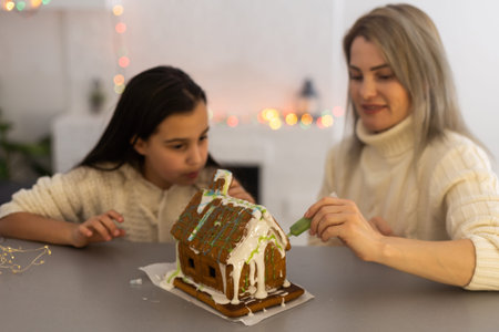 Family decorating gingerbread house on Christmas eve