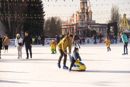 KYIV, UKRAINE - 2 January, 2023: Ice-skating people. People have fun in ice arena at the city ice...
