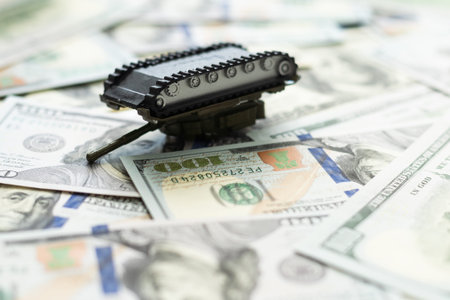 Tanks are placed on top of dollar bills. A metaphor for currency warfare, financial crises, trade wars, tariff penalties, international competition, war costs, and military spending.の写真素材
