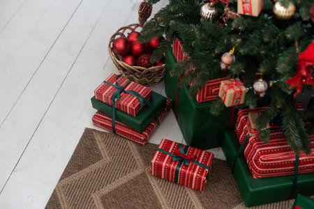 Beautiful Christmas gifts under fir tree on floor in room.の写真素材