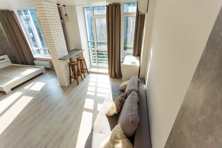 Modern room, home office interior. Room with sofa, desk, chair, small table and other furniture.