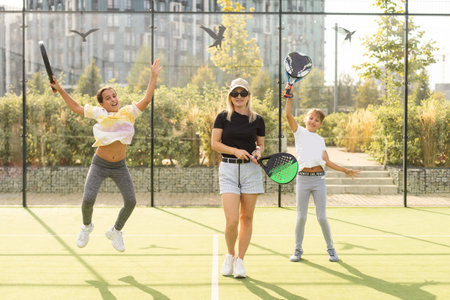 Active young woman practicing Padel Tennis with group of players in the tennis court outdoorsの写真素材