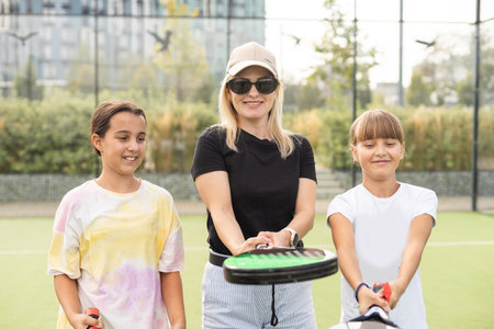 Active young woman practicing Padel Tennis with group of players in the tennis court outdoorsの写真素材