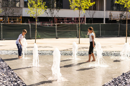 Happy kid playing in a fountain with waterの写真素材
