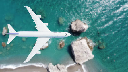 Airplane flying over beach with palm tree, white sand and turquoise oceanの写真素材
