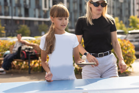Happy family playing ping pong in parkの写真素材