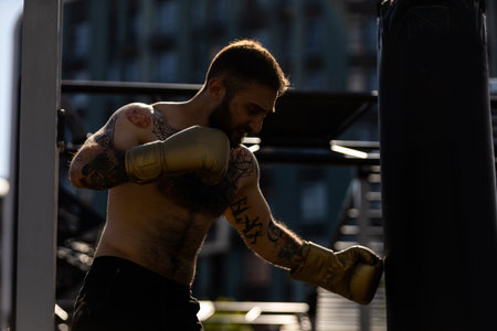 Man in boxing gloves is practicing on an outdoorの写真素材