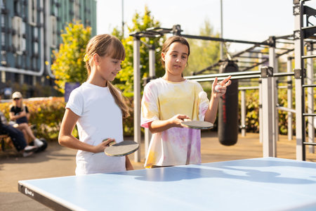 Cute girls playing ping-pong indoors
