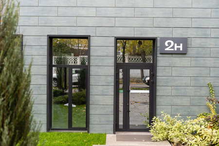 The front door of a office block, reflecting buildings in the glassの写真素材