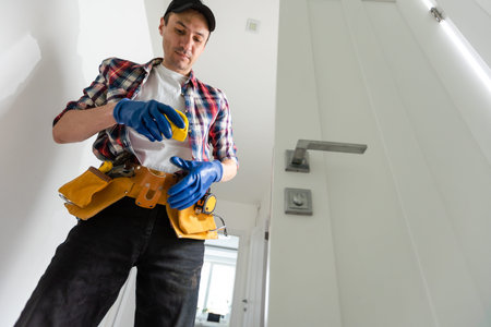 Repairman repairing door knob on interior door