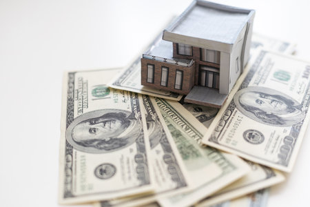 paper house model on background of US dollars banknotes. Housing market, purchase or rental of real estateの写真素材