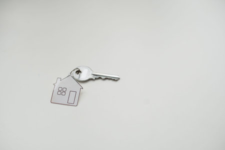 House key with trinket on white backgroundの写真素材