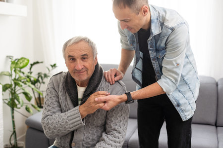 Grown up son asking for apologizes to offended stressed elderly senior daddy, sitting together on...