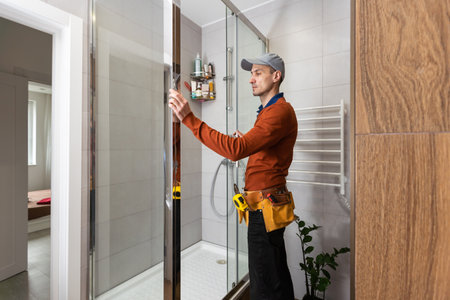 Professional handyman working in shower booth indoorsの写真素材