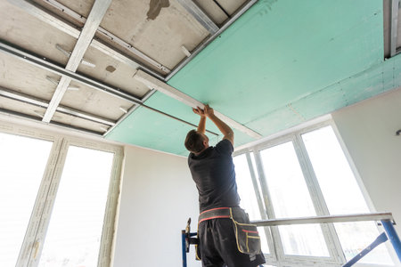 Two workers are mounted ceiling in the new flatの写真素材