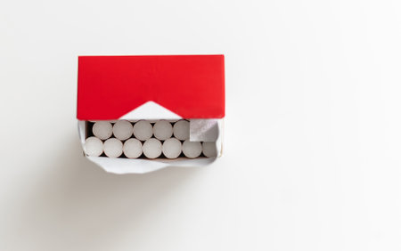 Cigarettes in an open red and white pack on a light tableの写真素材